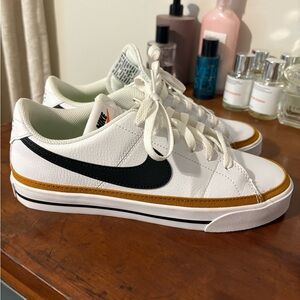 Nike White Sneakers with Black Swoosh and Gold Accent